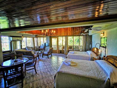 曼努埃尔安东尼奥绿色海岸酒店的酒店客房带两张床和一张桌子以及椅子。