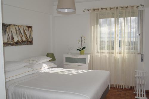 里斯本Vistas Sobre O Rio Tejo的白色的卧室设有床和窗户