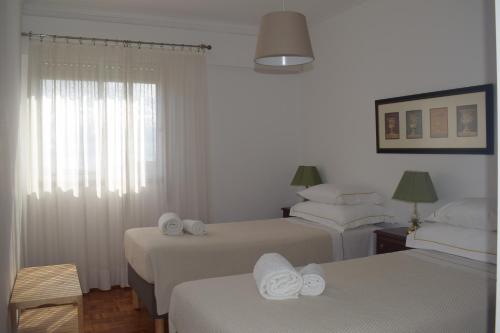 里斯本Vistas Sobre O Rio Tejo的酒店客房,配有两张带毛巾的床