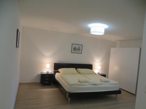 萨尔茨堡Premium City Apartment Amadeus的一间卧室配有一张带两个灯的床