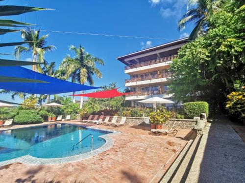 曼努埃尔安东尼奥绿色海岸酒店的一座带游泳池和大楼的度假村