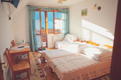 什恰夫尼察Willa Dutka的一间卧室设有两张床、一张桌子和窗户。