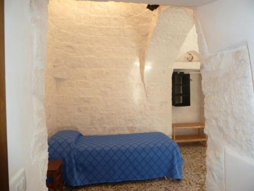 奇斯泰尼诺皮克罗特鲁洛乡村民宿的一间设有蓝色床的砖墙卧室