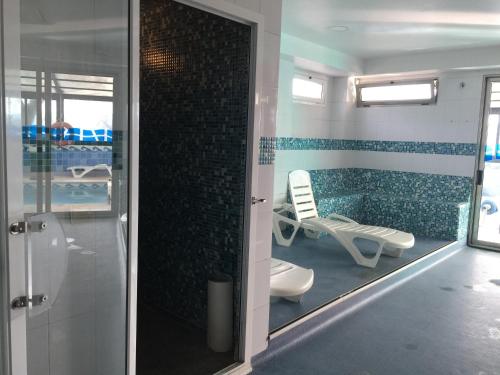 桑坦德圣米仑酒店的带淋浴、卫生间和椅子的浴室