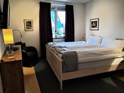 韦特兰达Rum i Centrum的一间卧室配有一张床、一张书桌和一个窗户。
