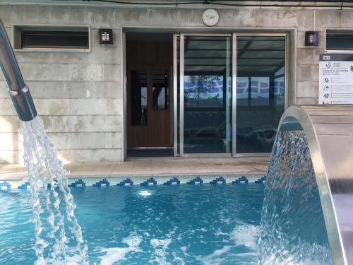 桑坦德圣米仑酒店的一座建筑前的带喷泉的游泳池