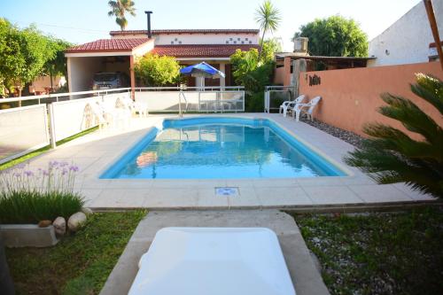 米拉马尔Departamentos MeliMar的一座带房子的庭院内的游泳池