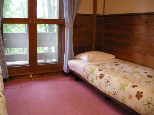 白马村林住宿加早餐旅馆的一间卧室设有一张床和两个窗户。