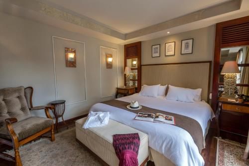 昆卡阿尔卡萨大厦酒店的酒店客房带一张大床和一把椅子
