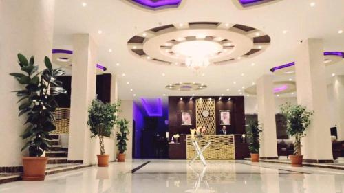 哈费尔巴廷Al Sharq Hotel的大型大堂设有大型吊灯和植物