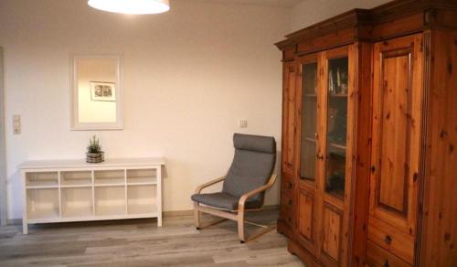 NeußenFerienwohnung Lipizzaner的客厅配有椅子和橱柜