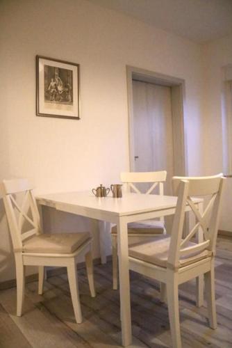 NeußenFerienwohnung Lipizzaner的一张带两把椅子的白色桌子和一张白色的桌子及椅子
