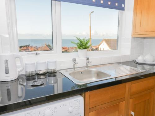 科尔温湾Bay View House的带水槽的厨房台面和2扇窗户