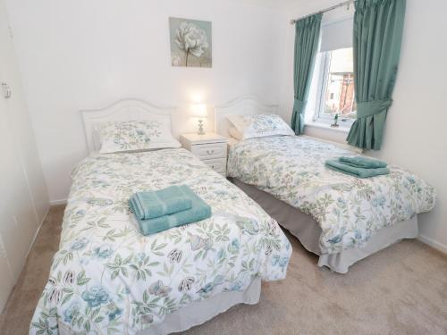 科尔温湾Bay View House的卧室内的两张床,配有绿色窗帘