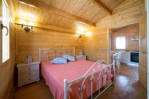 富尔纳里Chalet Tenuta Lacco的木制客房内的一间卧室,配有一张床
