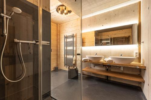 菲根Naturlodge Tirol - Naturverbunden im Zillertal的一间带两个盥洗盆和淋浴的浴室