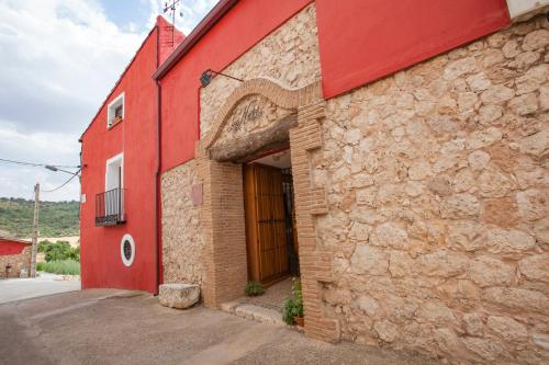 Rebollosa de Hita洛尼多德利博罗萨乡村民宿的红色的建筑,上面有一扇大门