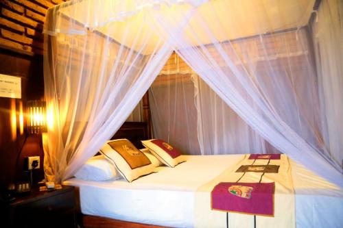 阿努拉德普勒D Family Resort的卧室配有带白色窗帘的天蓬床
