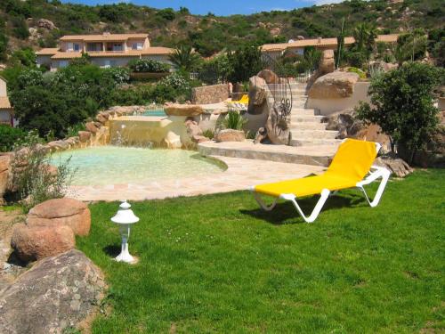 维琪奥港Résidence Liccia di Furu的坐在游泳池旁的草地上的黄色椅子