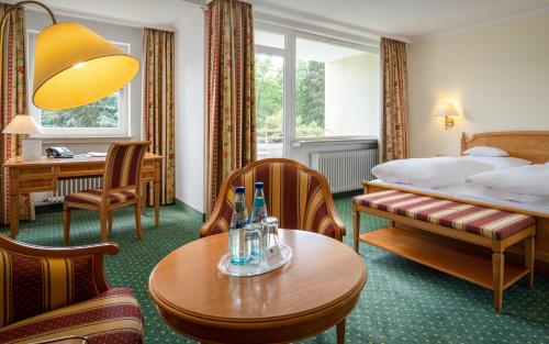 上乌瑟尔陶纳斯公园酒店的酒店客房带一张床、一张桌子和椅子