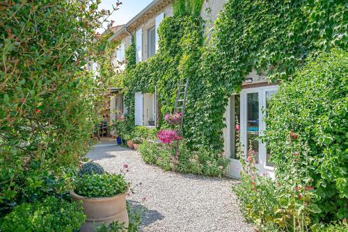 奥朗日Chambres d'Hôtes et Gîtes Le Mas Mellou的一座花园,在一座建筑前种有植物和花卉