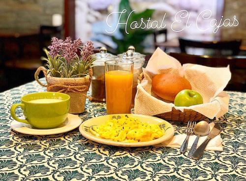 昆卡HOSTAL EL CAJAS的餐桌,上面放着一盘食物和一杯橙汁