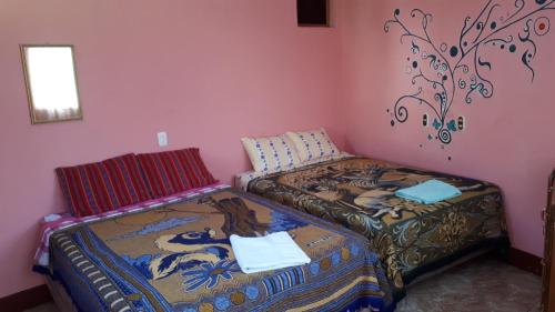 圣佩德罗拉拉古纳Hospedaje Lolita的粉红色墙壁客房中的两张单人床