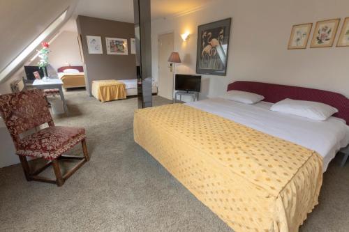克诺克－海斯特普林斯波德文酒店的一间卧室配有一张床、一把椅子和一张书桌