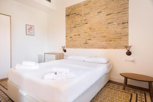 略夫雷加特河畔奥斯皮塔莱特Design Apartments by Olala Homes的砖墙房间内的一张白色床