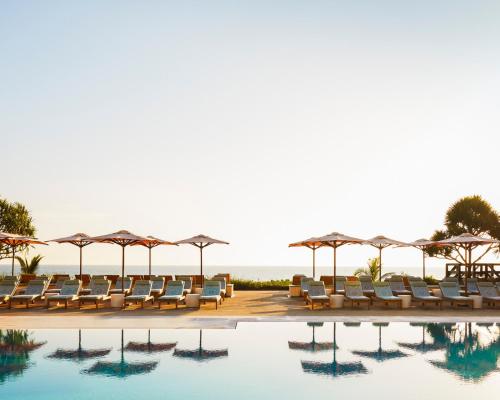 棕榈滩棕榈滩四季度假酒店的毗邻大海的带椅子和遮阳伞的游泳池