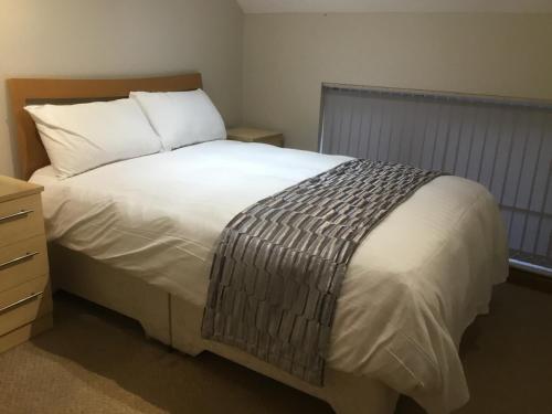 唐克斯特The Loco的卧室配有白色的床和木制床头板