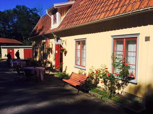 亨尼博斯特兰德Hunnebostrands vandrarhem Gammelgården的白色的建筑,有红色的屋顶和长凳