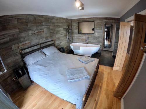 阿伯里斯特威斯46 Y Lanfa的一间卧室配有一张床、一个浴缸和一个水槽