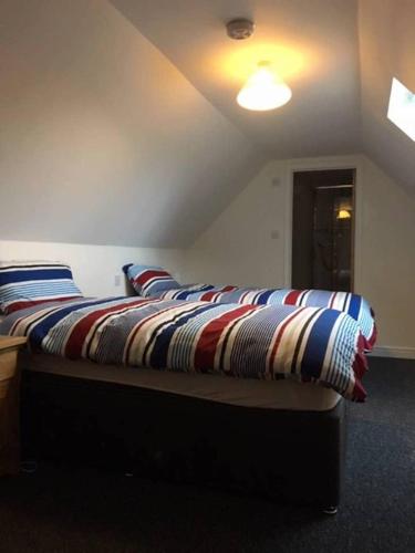 坎特伯雷Orchard Cottage的一张床上,床上有条纹毯子,放在房间里