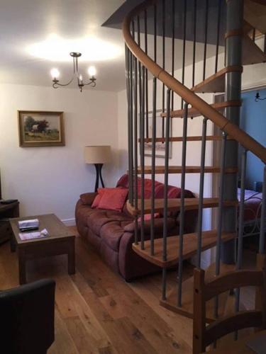 坎特伯雷Orchard Cottage的带沙发和螺旋楼梯的客厅