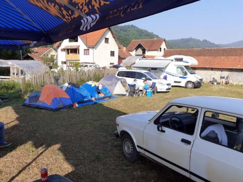 古察Dragacevska avlija - Camp的一群帐篷和一辆停在院子的汽车