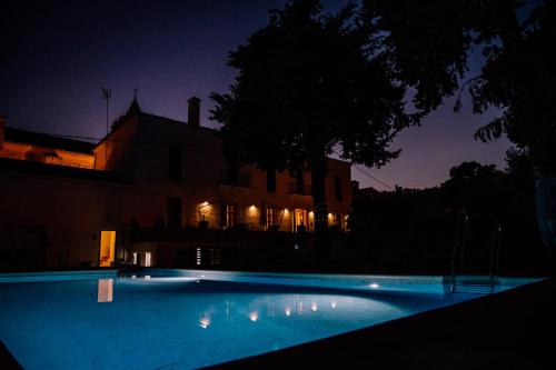 阿尔莫纳斯特尔拉雷亚尔HOTEL LUZ ALMONASTER的一座游泳池,在晚上在建筑物前