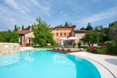 蒂耶内Borghetto San Biagio Relais Agriturismo的房屋前的大型游泳池