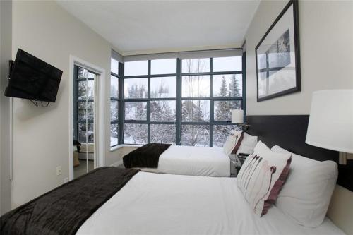 惠斯勒比尔阿尔派格洛夫公寓式酒店的一间卧室设有两张床和大窗户