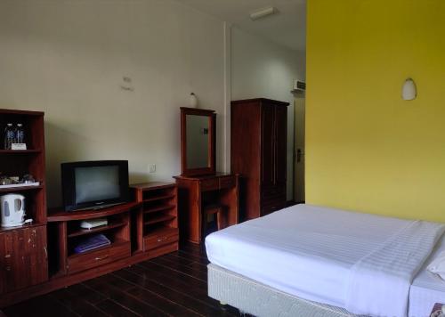 昆达桑纳瓦卢坤达萨山林小屋的一间卧室配有一张床和一台电视。