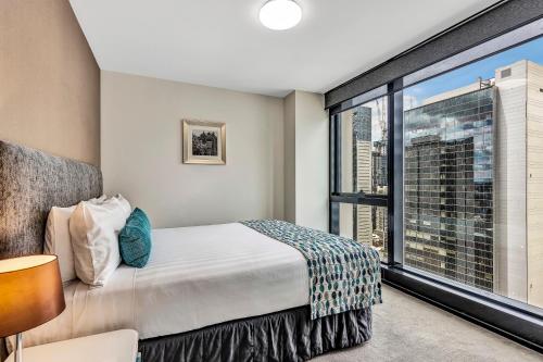 墨尔本飞马公寓式酒店的一间卧室设有一张床和一个大窗户