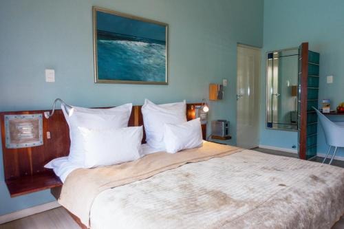 开普敦Rosedene Lodge - 24h solar with pool and garden的卧室配有带白色枕头的大床
