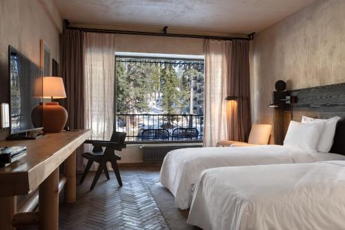 巴库里阿尼Rooms Hotel Kokhta的酒店客房设有两张床、一张书桌和一个窗户。