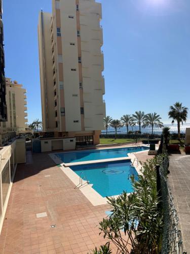 马贝拉Playa Fontanilla Apartments的一座高楼前的游泳池
