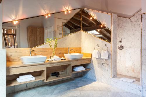 富尔普梅斯克里斯特尔运动酒店的一间带两个盥洗盆和大镜子的浴室