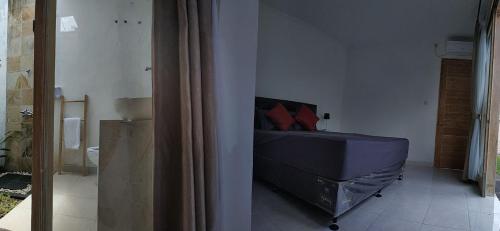 BanjarVilla Santika的一间卧室配有一张带红色枕头的床