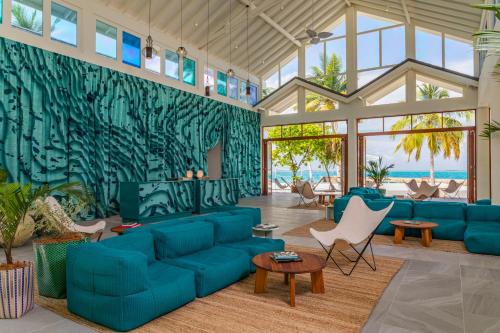 鲁阿环礁The Standard, Huruvalhi Maldives的大型客厅配有蓝色的沙发和椅子