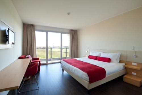 维洛尔巴UNAHOTELS Le Terrazze Treviso Hotel & Residence的酒店客房设有一张床和一个大窗户