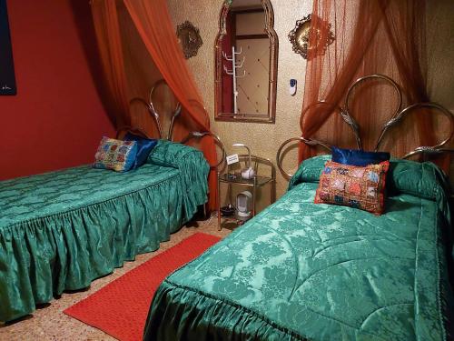阿利坎特Alicante Room and gayfriendly的一间卧室设有两张绿色的床和镜子