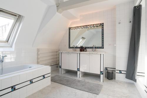阿姆斯特丹Empire suites roof terras的白色的浴室设有浴缸和镜子